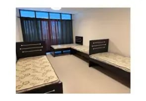 A sharing room in Al Rigga with four single beds