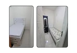Small single bed with black wardrobe.