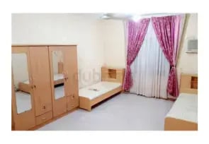 A room in Al Rigga with two single beds and a wardrobe